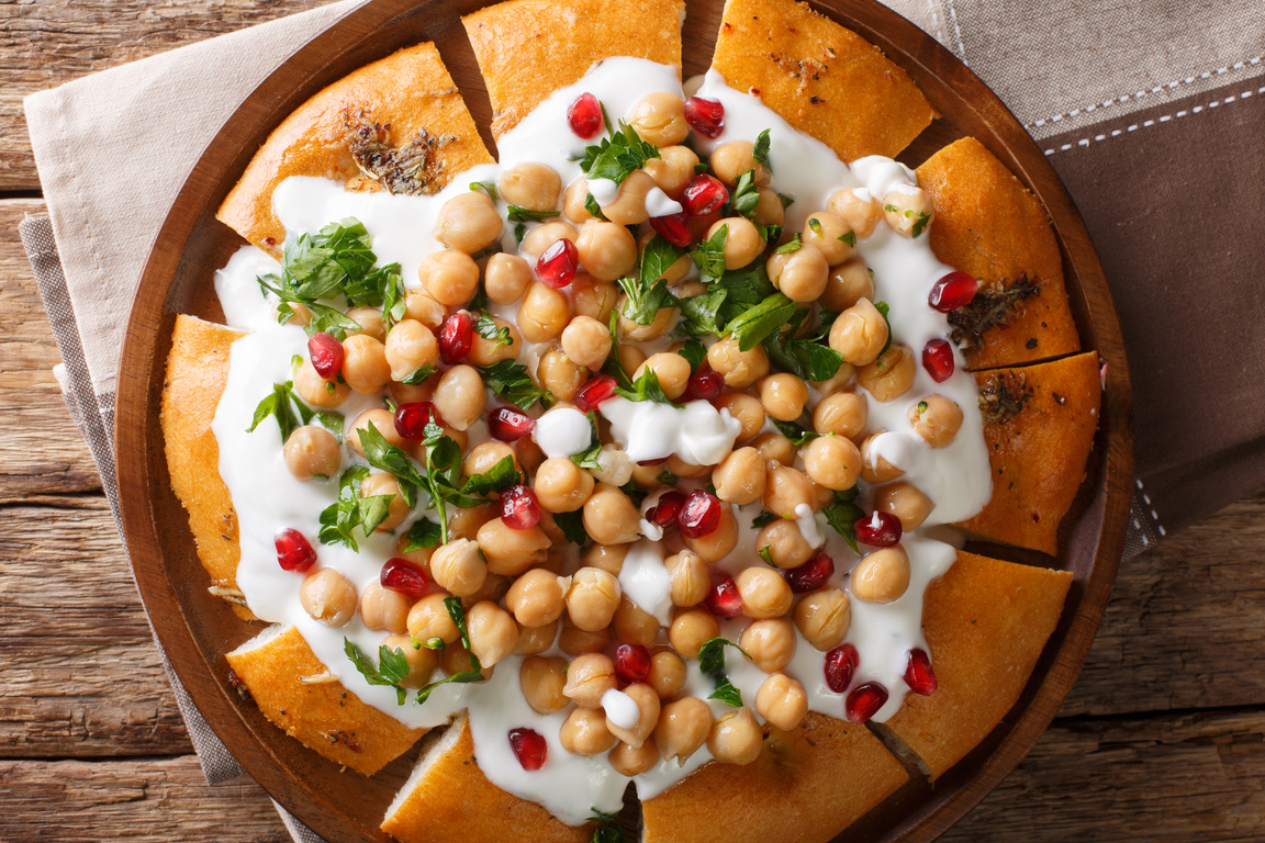 Fatteh Pita with Chickpeas and Yogurt traditional arabic dish closeup on a plate. horizontal top view